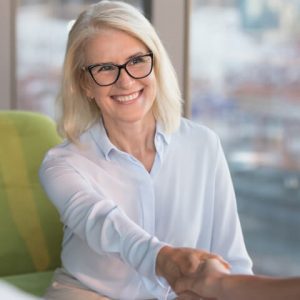 patient smiling shaking hands with dentist