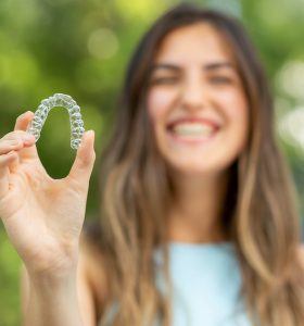 woman holding inivisalign aligner