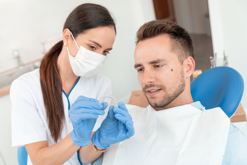 orthodontist showing patient invisalign aligner